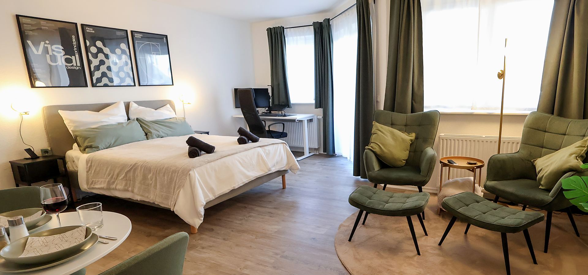 Modernes Apartmentzimmer mit Bett, Arbeitsplatz und Sitzbereich